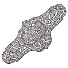 An American Art Deco platinum brooch with diamonds by E. M. Gattle & Co. The brooch has 168 old European-cut diamonds with an approximate total weight of 4.50 carats, and 5 square-cut diamonds with an approximate total weight of .75 carats. The total approximate diamond weight of the brooch is 5.25 carats, H/I color, VS clarity. The brooch centers on a dimensional jardinière flanked by pierced foliate elements with a milgrain set diamond border. Circa 1920. E.M. Gattle Co. was founded by Emanue Art Deco Diamond Brooch, American Art Deco, Art Deco Jewellery, 1920s Jewelry, Brooch Art, Art Deco Brooch, Jewelry Antique, Gold Art Deco, Circle Diamond