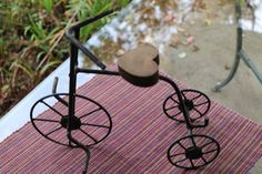 a pair of black metal wheels sitting on top of a pink and white table cloth