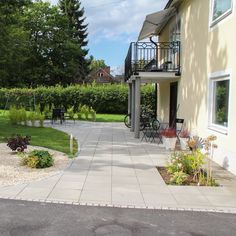 a house with a patio and landscaping in the front yard