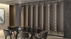 a dining room table with chairs and a wine rack on the wall in front of it