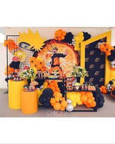 an orange and black halloween party with balloons, decorations, and desserts on the table