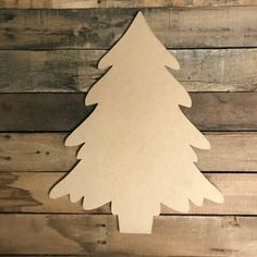 a wooden cutout of a christmas tree on a wood wall with planks in the background