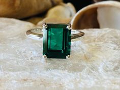 This classic 4 prong setting contains a beautiful 4.00ct. lab created emerald cut emerald. The emerald cut stone measures approximately 10x8mm. The ring is available in sterling silver, and 14k white, yellow, or rose gold. This ring makes a great promise or engagement ring. Emerald is the birthstone for May. Please send me a message if you need a size not listed. All items are handmade by me in my shop in Woodbridge, NJ. Please message me with any questions. Emerald Cut Birthstone Emerald Ring, Emerald Cut Diamond Ring For May Birthstone, May Birthstone Emerald Cut Emerald Ring, Emerald Cut Emerald Ring With Vvs Clarity, Classic Emerald Ring With Rectangular Stone, Radiant Cut Emerald Ring With Vvs Clarity, Octagonal Solitaire Emerald Ring, Solitaire Emerald Ring With Radiant Cut, Classic Square Cut Emerald Ring With Accent Stones