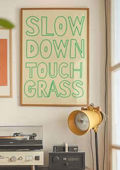 an old record player sitting on top of a table next to a lamp and poster