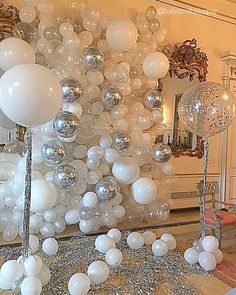 white balloons are hanging from the ceiling in front of a mirror