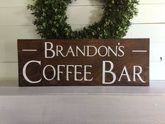 a wooden sign that says brandon's coffee bar on top of a shelf next to a wreath