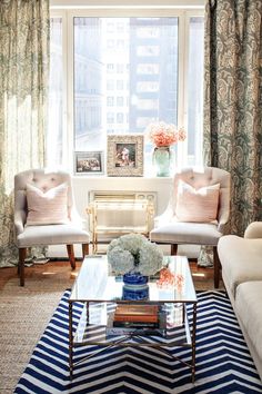 a living room with couches, chairs and a coffee table in front of a window