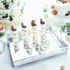 a tray with candles on top of it next to cupcakes and other desserts