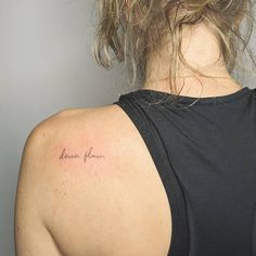 a woman with a tattoo on her back shoulder