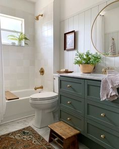 a bathroom with green cabinets and white walls