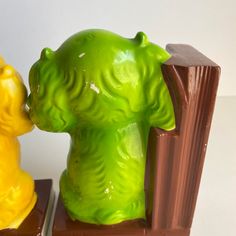 two yellow and green bear figurines sitting next to each other