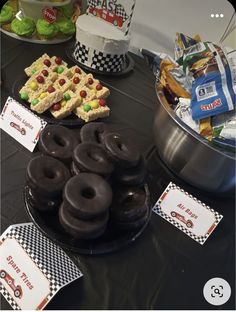 a table topped with chocolate covered donuts and candy bars