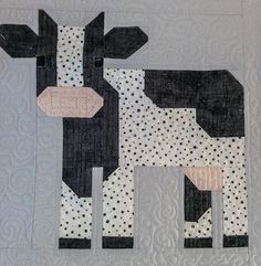 a black and white quilted cow with polka dots