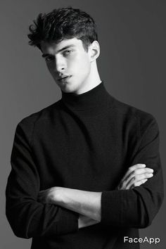 a man in a black turtle neck sweater posing for the camera with his arms crossed