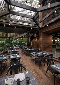 an empty restaurant with tables and chairs set up for dinner in the middle of it