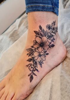 a black and white flower tattoo on the foot