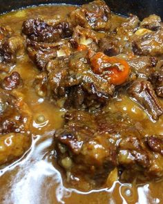 meat and vegetables are being cooked in a pot