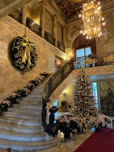 a christmas tree in the middle of a grand staircase