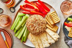 a plate with crackers, celery, carrots and other food on it