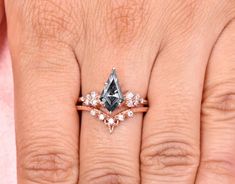 a woman's hand with an engagement ring on it and a diamond in the middle