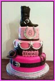 a pink and black cake with boots on top