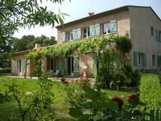 the house is surrounded by greenery and flowers