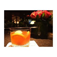 a glass filled with orange juice on top of a table