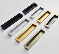 four different types of drawer pulls on a white surface with black, gold and silver handles