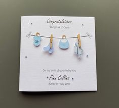 a card with clothes pins and baby items hanging from it's clothes pegs