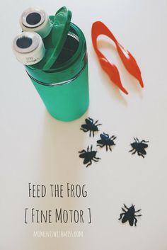 a green cup with scissors next to it on top of a white surface that says feed the frog / five motor 1