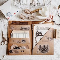 an assortment of crafting supplies laid out on a lace tablecloth with scissors and paper