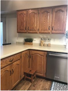 a kitchen with wooden cabinets and white counter tops, an oven and dishwasher