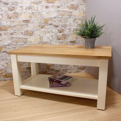 a table with books and a potted plant on it in front of a brick wall