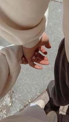 two people holding hands while standing next to each other