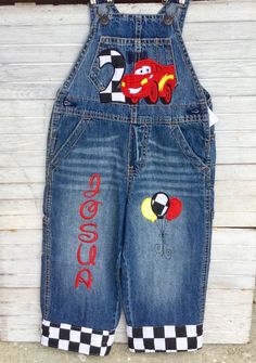 the overalls are decorated with cars and checkered fabric, while the overalls have an applique on them