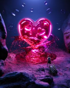 a man standing in front of a heart shaped neon sign on top of a rock