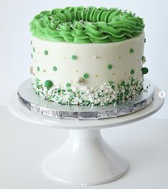 a white cake with green frosting and sprinkles