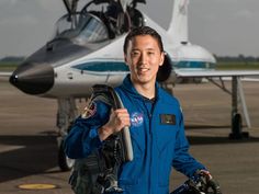 a man standing in front of an airplane on the tarmac with his backpack and helmet