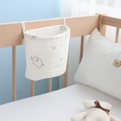 a teddy bear sitting on top of a bed next to a white pillow and blanket