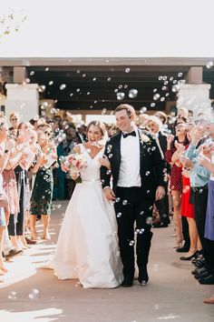 a newly married couple walking down the aisle with bubbles in front of them