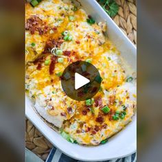 a casserole dish with cheese and green onions in it on a wicker place mat