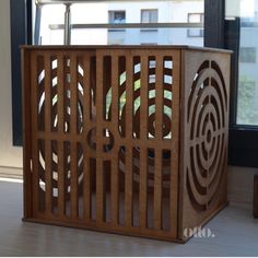 a wooden box sitting on top of a hard wood floor next to a large window