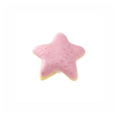 a pink star shaped cookie with sprinkles on it's side against a white background