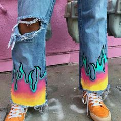 the legs and ankles of a person with painted jeans