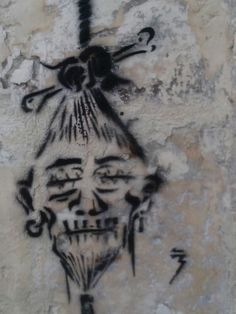 graffiti on the side of a building with a skull and crossbones painted on it