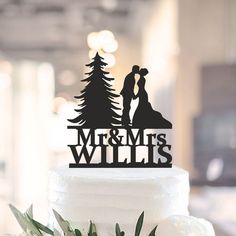 a wedding cake topper that says mr and mrs willis with trees in the background