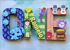 the letter e is made up of wooden letters with cartoon characters and animals on them