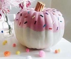 a pink and white pumpkin with sprinkles on it