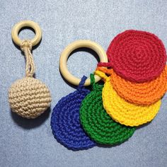 a crocheted keychain with a wooden ring on top of it next to a set of knitted rings