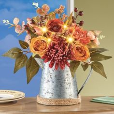 an arrangement of flowers in a metal watering can